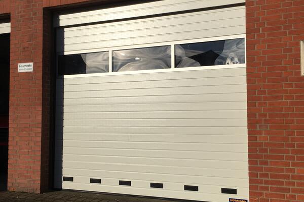 Hörmann Industrie-Sektionaltor ISO40 Sicke stucco geprägt RAL 9002 grauweiß mit Blende und Fenstersektion