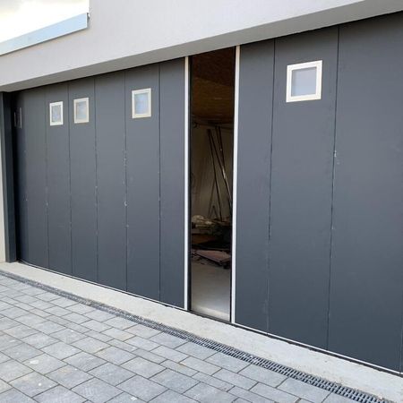 Normstahl Seitensektionaltor Typ Top Style, 7690 x 2485 mm, RAL 7016 Anthrazitgrau, mit Fenstern