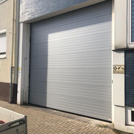 ConDoor Industrie-Sektionaltor ISO40, komplett geschlossen, RAL 9006 Weißaluminium, waagerechte Sicke, Stucco geprägt, 4300 × 4100 mm
